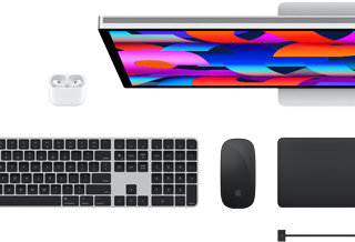 Top view of Mac accessories: Studio Display, AirPods, Magic Keyboard, Magic Mouse, and Magic Trackpad